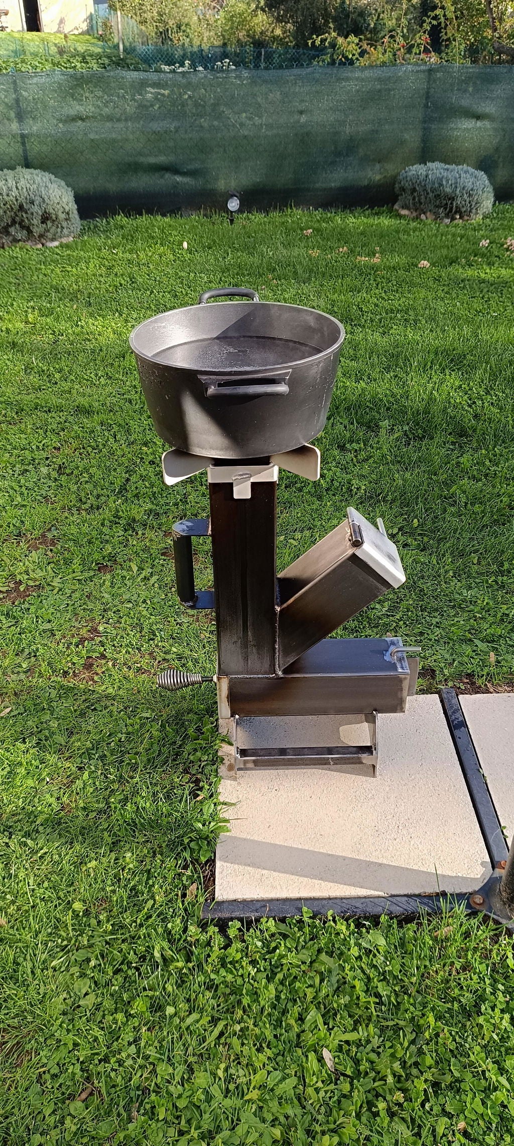 Photo de Johnny B. : son Rocket Stove utilisé avec une cocotte en extérieur.